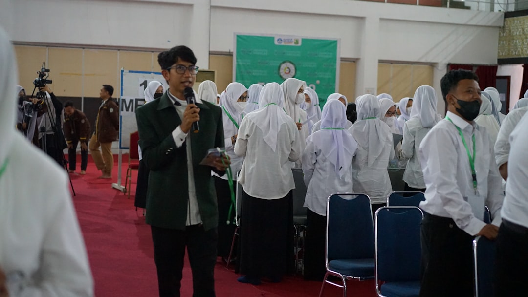 a man speaking into a microphone in front of a group of people