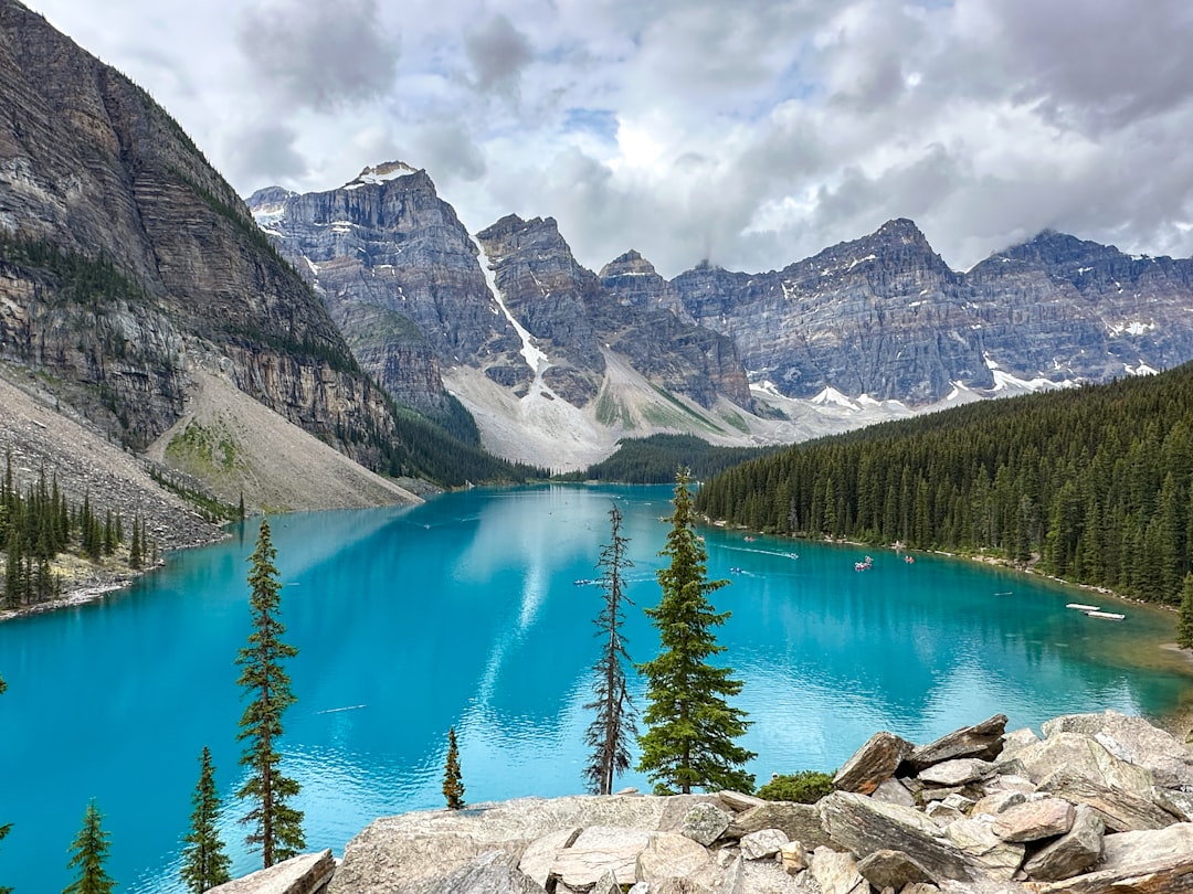 Turquoise lake reflects mountains and pine trees