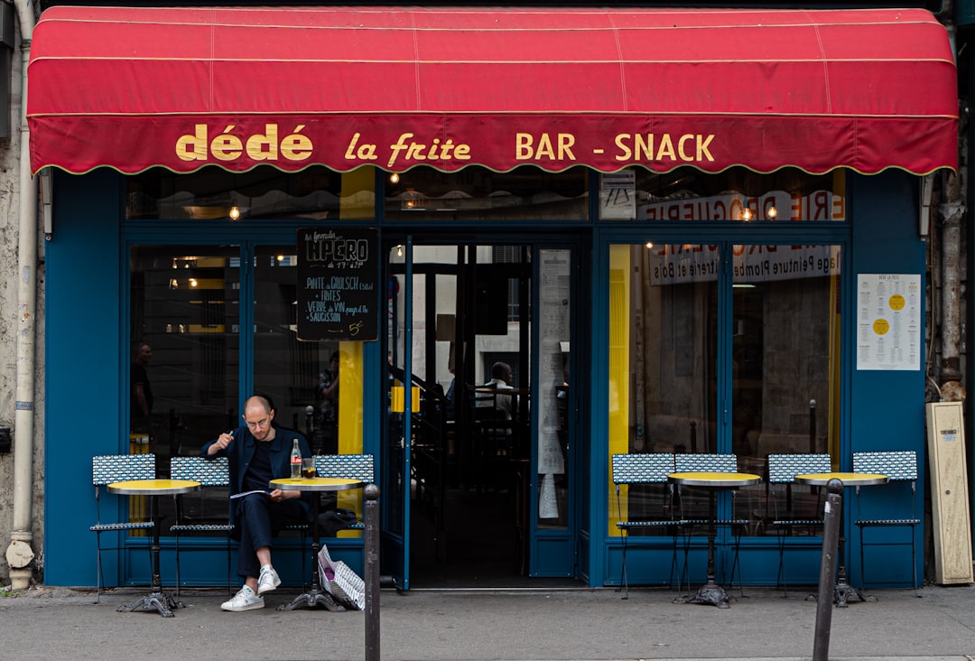 a person sitting at a table outside of a restaurant